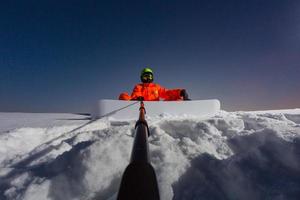 snowboardåkare gör en selfie med sin actionkamera på toppen av skidbacken foto