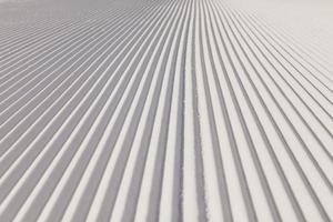 textur av ny preparerad snö på tom skidbacke foto