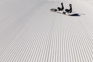 utrustning för snowboardåkning på en ny preparerad snö foto