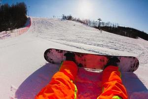 synvinkel skott av en manlig snowboardåkare sitter på snön foto