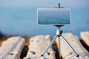 smartphone på stativ gör bilderna av den vackra vattenytan foto