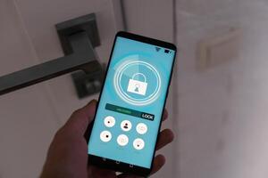 man med mobil telefon använder sig av smart Hem säkerhet systemet Ansökan foto
