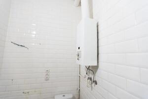 bruten modern vatten gas värmare Nästa till dusch stuga inuti elegant rena badrum interiör. foto