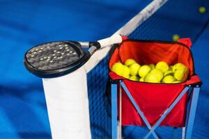 paddla tennis racket och bollar på de blå paddla domstol foto