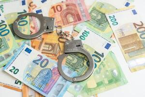 par av metall polis handklovar på euro sedlar pengar kontanter bakgrund. korruption, smutsig pengar, hasardspel eller finansiell brottslighet idéer begrepp. foto