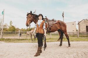 söt kinesisk cowgirl medan tar vård av henne häst foto