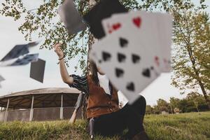 porträtt av en skön kinesisk kvinna cowgirl spelar med poker kort foto