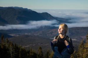 kvinna njuter av den friska luften i bergen medan hon vandrar till toppen av richardson foto