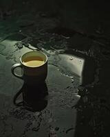 ångande te kopp på fuktig yta foto