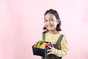 liten kvinna asiatisk barn som visar henne matlåda foto