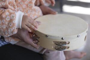 barnets händer med tamburin i de levande rum närbild foto