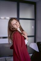 porträtt av en ung kvinna i en röd kontor kostym foto