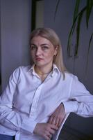 porträtt av en blond kvinna i jeans och en vit skjorta i de kontor foto