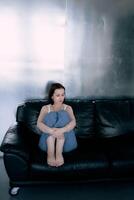 ung Tonårs flicka stridande hjärna cancer på Foto skjuta i studio, metall vägg, reflexion, svart soffa