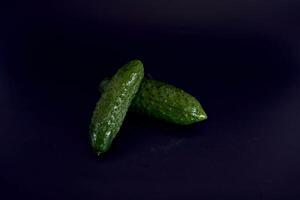 färsk grön gurka på en svart bakgrund foto