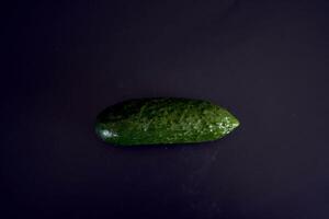 färsk grön gurka på en svart bakgrund foto