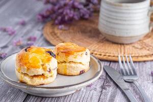 närbild av traditionell brittiskt scones på en tallrik med en kopp av te och blomma suddig bakgrund. Plats för text foto