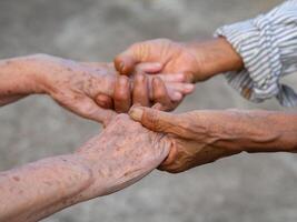 närbild bild av skakning händer mellan senior kvinnor. enhet och partnerskap begrepp foto