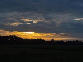 soluppgång med mörk moln formationer med natur bakgrund foto