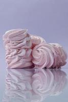 rosa hemlagade marshmallows på lila bakgrund foto