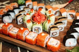 blandad sushi rullar på en trä- styrelse foto