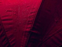 röd paraply textur med vatten droppar för regnig dag bakgrund. foto