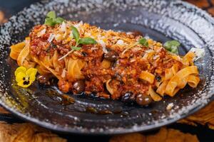tagliatelle al ragu spaghetti med oliver eras i tallrik isolerat på tabell sida se av italiensk snabbmat foto