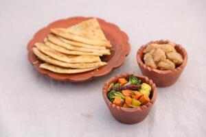 desi frukost blandad grönsaker, Halwa och paratha eras i maträtt isolerat på bakgrund topp se av bangladesi frukost foto