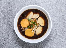 thai ris nudel i soppa med blandad thai korvar eras i skål isolerat på grå bakgrund topp se av hong kong mat foto