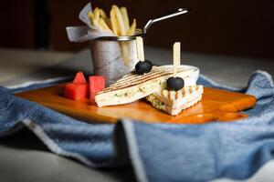 grillad kyckling smörgås med frites hink eras i trä- styrelse isolerat på servett sida se av frukost mat foto