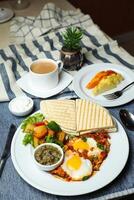 Shakshuka med vegetabiliska sallad inkludera tomat, potatis, sallad blad och morot med te, kaffe, och ljuv melon eras på mat tabell topp se friska frukost foto