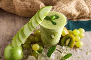 blandad äpple, kiwi och vindruvor smoothie eras i disponibel glas isolerat på tabell sida se av friska dryck foto