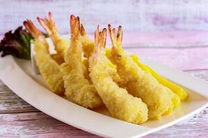 friterad tempura räkor eras i maträtt isolerat på tabell närbild topp se av grillad skaldjur foto