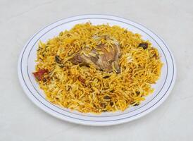 kryddad kyckling biryani eras i tallrik isolerat på grå bakgrund sida se av pakistansk och indisk kryddor mat foto