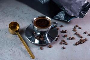varm turkiska kaffe tjänande i kaffe kopp med skopa och bönor sida se på grå bakgrund foto