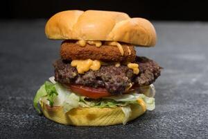jalapeno nötkött burger inkludera smält ost, kål, tomat och sallad blad isolerat på mörk grå bakgrund sida se av snabb mat smörgås foto