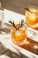 glas av orange juice med rosmarin garnering foto