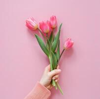 hand innehav knippa av rosa tulpaner foto