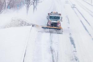 snöplog som tar bort snön från motorvägen under en snöstorm foto