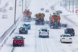 trädradade snöplogar som röjer motorvägen foto