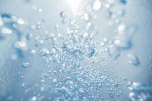 abstrakta undervattensluftbubblor som går upp till vattenytan med solljus foto