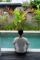 villa friskvård, asiatisk man modell praktiserande yoga, lotus utgör förbi slå samman, bali indonesien foto