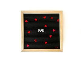 svart brev styrelse med stavat ord jag kärlek du med konfetti hjärtan. kärlek och romantik. foto