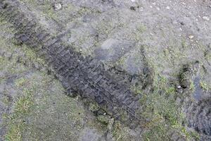 hjul Spår på lera. spår av en traktor eller tung av vägen bil på brun lera i våt äng foto