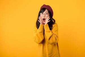 Wow. ung emotionell överraskad 30s asiatisk kvinna stående med öppen mun. skön kvinna halv längd främre porträtt isolerat på gul studio bakgrund. mänsklig känslor, ansiktsbehandling uttryck begrepp. foto