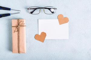 fars dag gåva, hjärtan, glasögon, skruvmejslar och bit av papper på en blå bakgrund foto