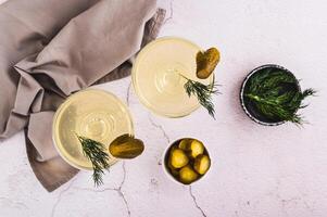 trendig Martini cocktails med ättiksgurka och dill i glasögon på de tabell topp se foto