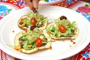 traditionell tostada, klassisk av mexikansk kök med sallad, hackad tomater, friterad kyckling pommes frites foto