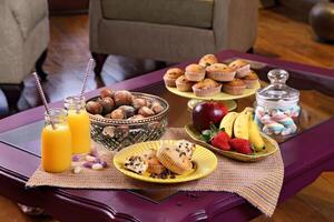eftermiddag mellanmål med muffins och orange juice i de levande rum foto
