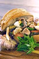 panorera bagnat, franska smörgås med tonfisk, aliche, tomat, vitlök, sallad, ägg och senap på bröd foto